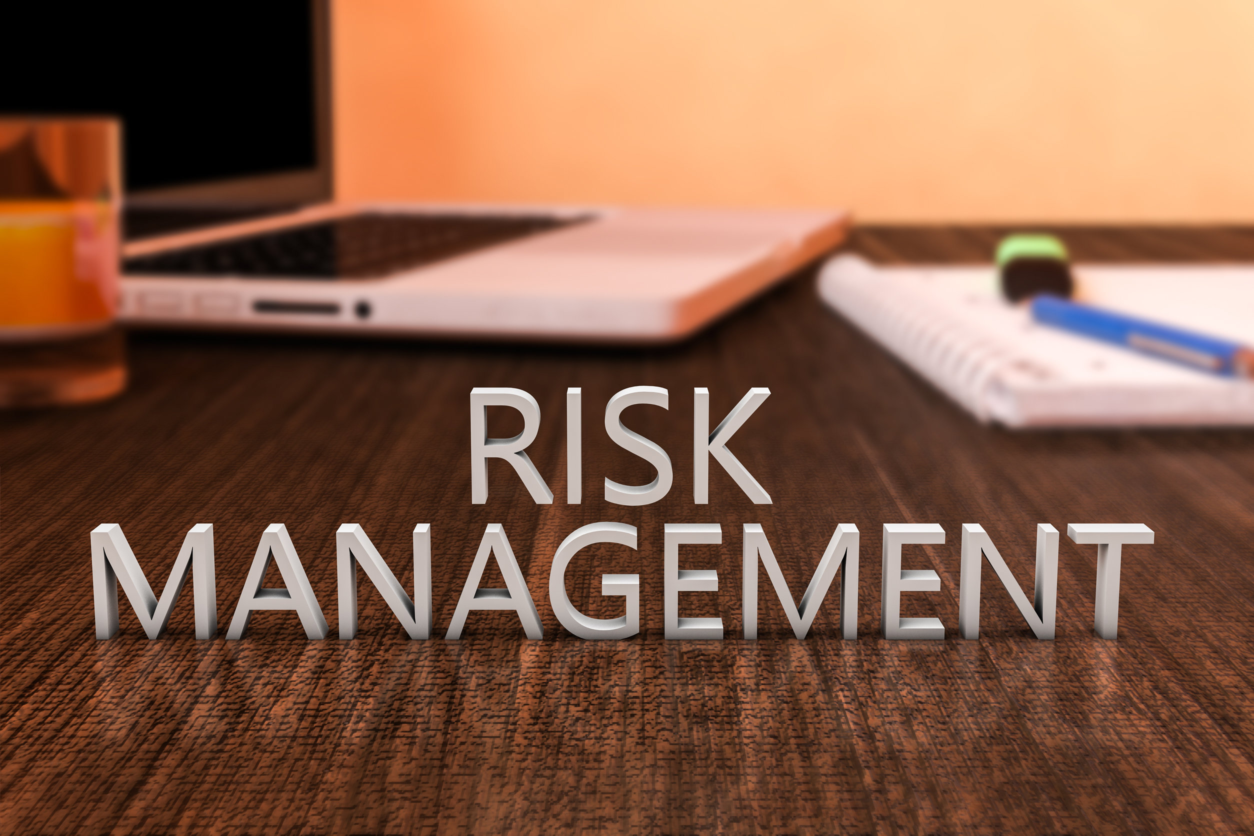 Risk Management - letters on wooden desk with laptop computer and a notebook. 3d render illustration.